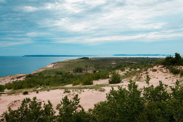 Fototapeta na wymiar Landscape shot of the Sleeping Bear Dunes with Lake Michigan and the South Manitou Island in the background