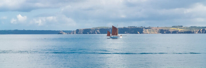 Fototapeta na wymiar old boat with beautiful bright sails, traditional boat in Brittany, panorama 