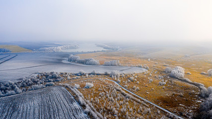 Snowy meadow with forest strips and empty agrarian fields. Winter landscape.