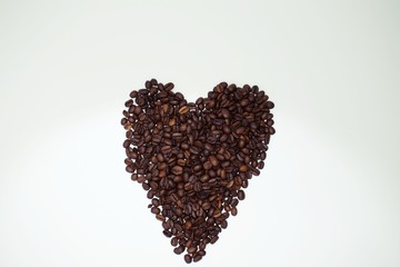 Whole coffee beans shaped into a heart