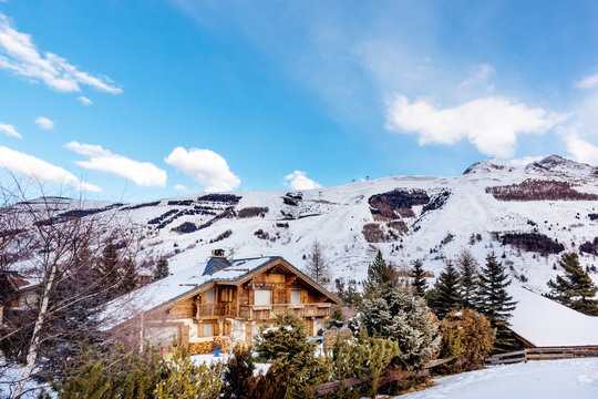 View on alpine village and mountain range with high snowy peaks, Les deux Alpes, French Alps