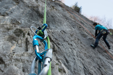 Abseiling with double rope from a mountain wall, close up on the safety equipment