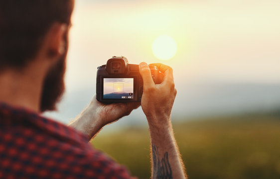 travel photographer. man traveler with camera  at sunset in nature.