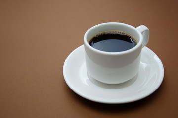 Coffee cup isolated on brown table. Coffee drink with copy space.