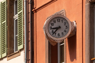 Fototapeta na wymiar two-faced clock at the facade of a house in rue Rapp, Colmar, France