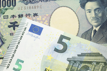 A one thousand Japanese yen bank note, close up in macro with a five Euro European bank note