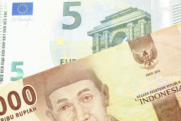 An orange five thousand Indonesian rupiah bank note with a five Euro note 