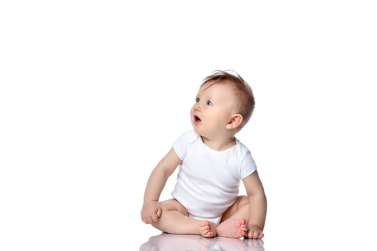 Infant child baby boy kid with blue eyes sitting in white body t-shirt with blank copy text space isolated on a white 