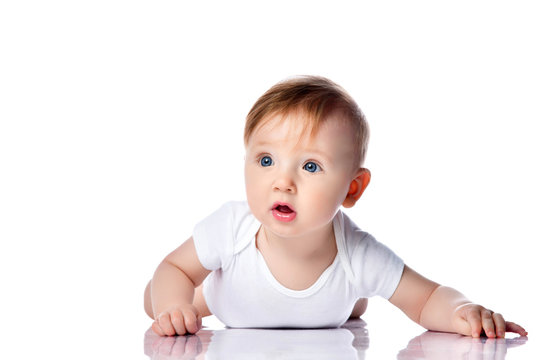 Infant child baby boy kid with blue eyes happy smiling screaming lying on a floor isolated on a white background