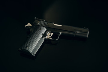 1911 handgun pistol on glass