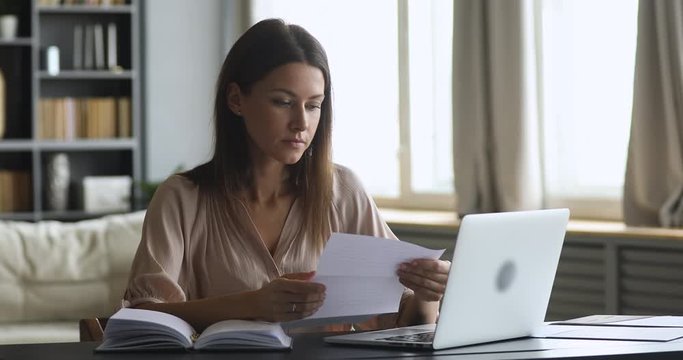 Frustrated shocked woman feeling upset reading bad news in letter