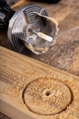 Wood hole saw and raw board. Making holes in raw wood.