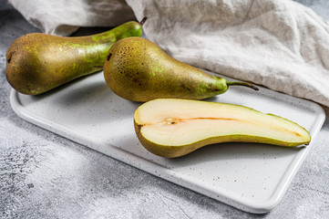 Pears on a ceramic cutting Board. Farm eco pears. Gray background. Top view