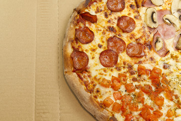 Flat lay of tasty italian pizza on on cardboard box. Cheese and peppers. Delicious food. photo can be used for pizzeria menu