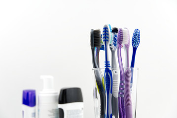 Toothbrushes in glass at bathroom isolated over white background.