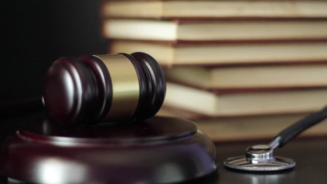 Judge's gavel and stethoscope. Judge hitting hammer three times