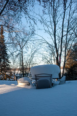 patio furniture buried under snow-vertical