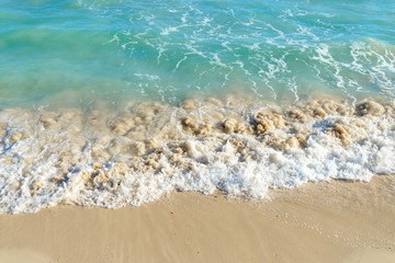 Wave on a sandy beach in summer