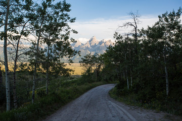A road through the mountains looking at the mountains in Grand Teton National Park. 