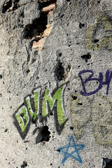 An old space observatory wall, destroyed during the war with graffiti which says boom.