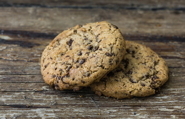 Two Freshly Baked Chocolate Cookies on Rustic Wooden Table. Sweet Biscuits. Homemade pastry.