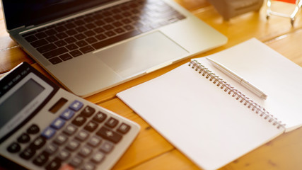 Using the calculator and laptop, calculate the cost. Cost calculation concept