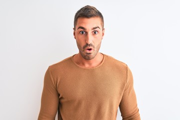 Obraz premium Young handsome elegant man wearing winter sweater over isolated background afraid and shocked with surprise expression, fear and excited face.