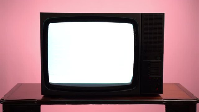 Old vintage television on pink background. Broken TV screen, static noise and transmission. Noise interference, switch on and off, retro style TV