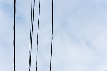 Electrical wires on blue sky with clouds background