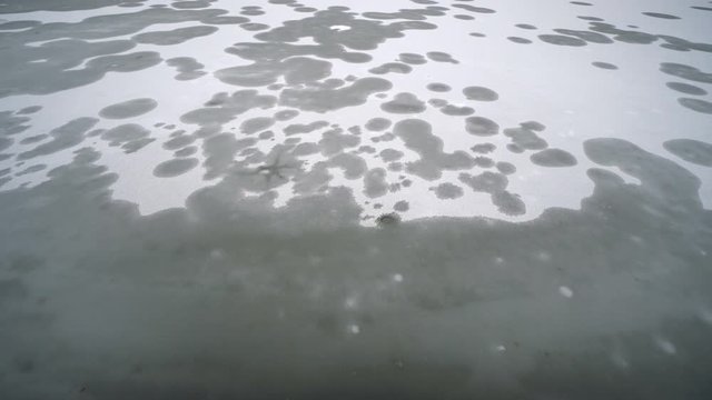 Frozen lake with pattern of the bubbless of deep gas under the surface