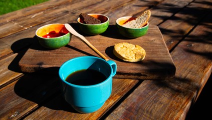 breakfast on sunday morning, cup of coffee with mermalade and home made bread and biscuits on wooden table