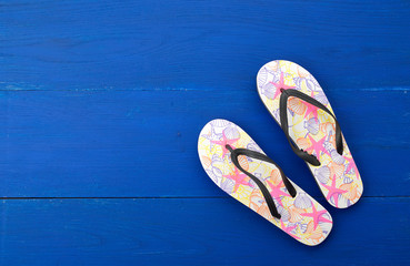 Flip flop in flat style on blue wooden background