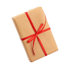 rectangular box wrapped in brown paper and tied with a red bow, gift isolated on white background