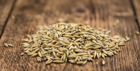 Portion of healthy Oat on an old wooden table (selective focus; close-up shot)