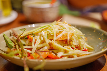 Close up view of Thai spicy green papaya salad, Som Tum, with dry shrimp .
