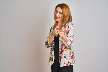 Young caucasian business woman wearing spring floral jacket suit over isolated background pointing fingers to camera with happy and funny face. Good energy and vibes.