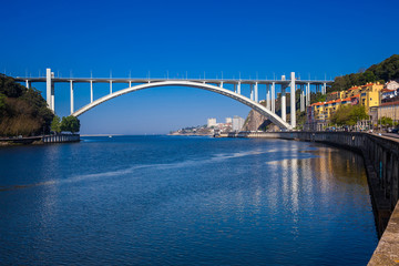 Obraz premium View of the Douro River mouth and the Arrabida Bridge in a beautiful early spring day at Porto City in Portugal