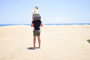 Young beautiful couple smiling happy and confident. Woman sitting on man shoulders with smile on face at the beach