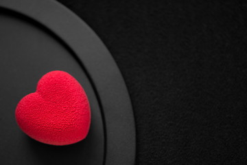 Valentines day concept. Red heart-shaped velvet cake on a black background.  