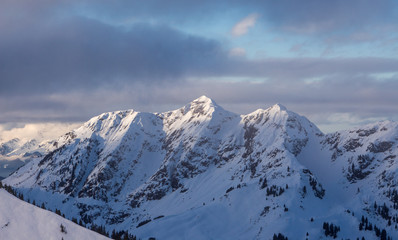 Mountain portrait Saalbach sunset clouds perfect blue sky purple light snowy mountainscape