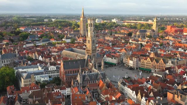 Rising aerial sweeping shot of the main market square in Bruges, Wide aerial shot of the city center, and the medieval Belfry bell tower.