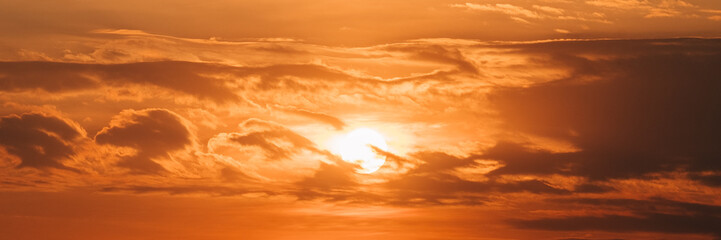 Beautiful panoramic shot of of the sun looking bigger than usual and surrounded by clouds. The sky...