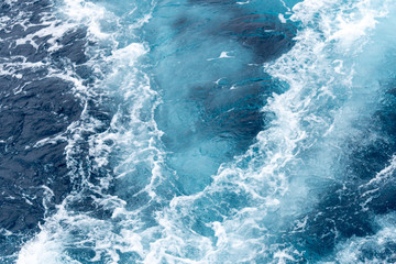 Wave create by ship sails pass through the sea water. Turbulance flow of sea water happen by the ship moving.