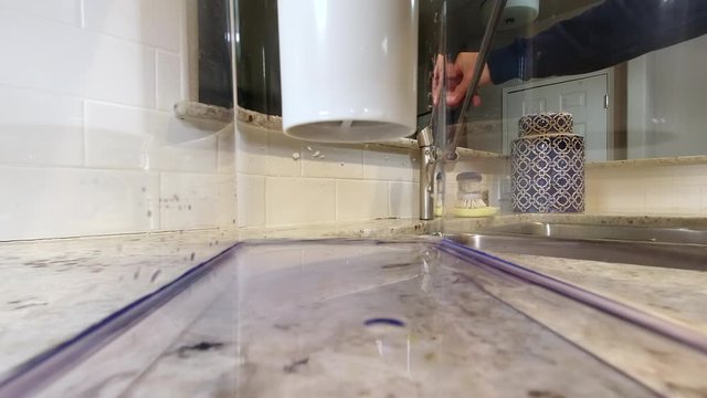 View from inside home water filtration pitcher while being filled with tap water