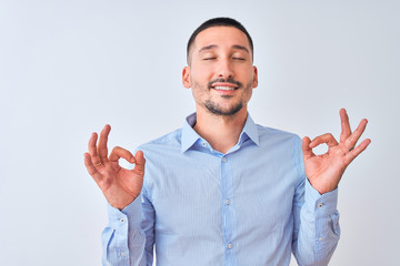 Young handsome business man standing over isolated background relax and smiling with eyes closed doing meditation gesture with fingers. Yoga concept.