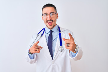 Young doctor man wearing stethoscope over isolated background pointing fingers to camera with happy and funny face. Good energy and vibes.