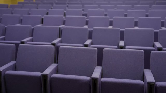 Pan over empty seats in a small auditorium or theatre
