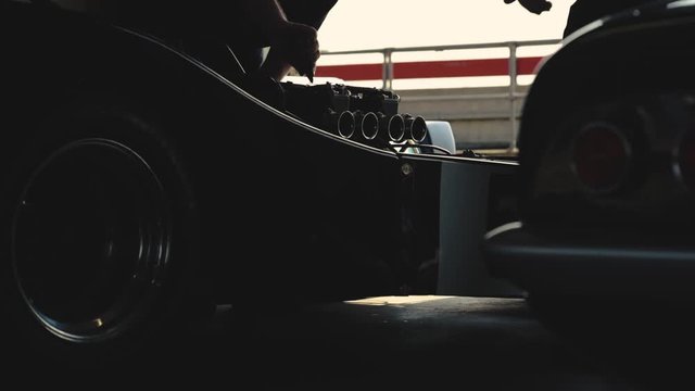 Mechanics working on a sports car.