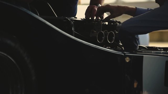 Mechanics working on a sports car.
