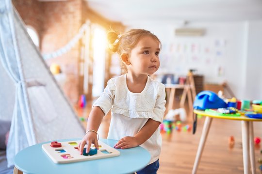 Young beautiful toddler learning mathematics playing with maths game at kindergaten